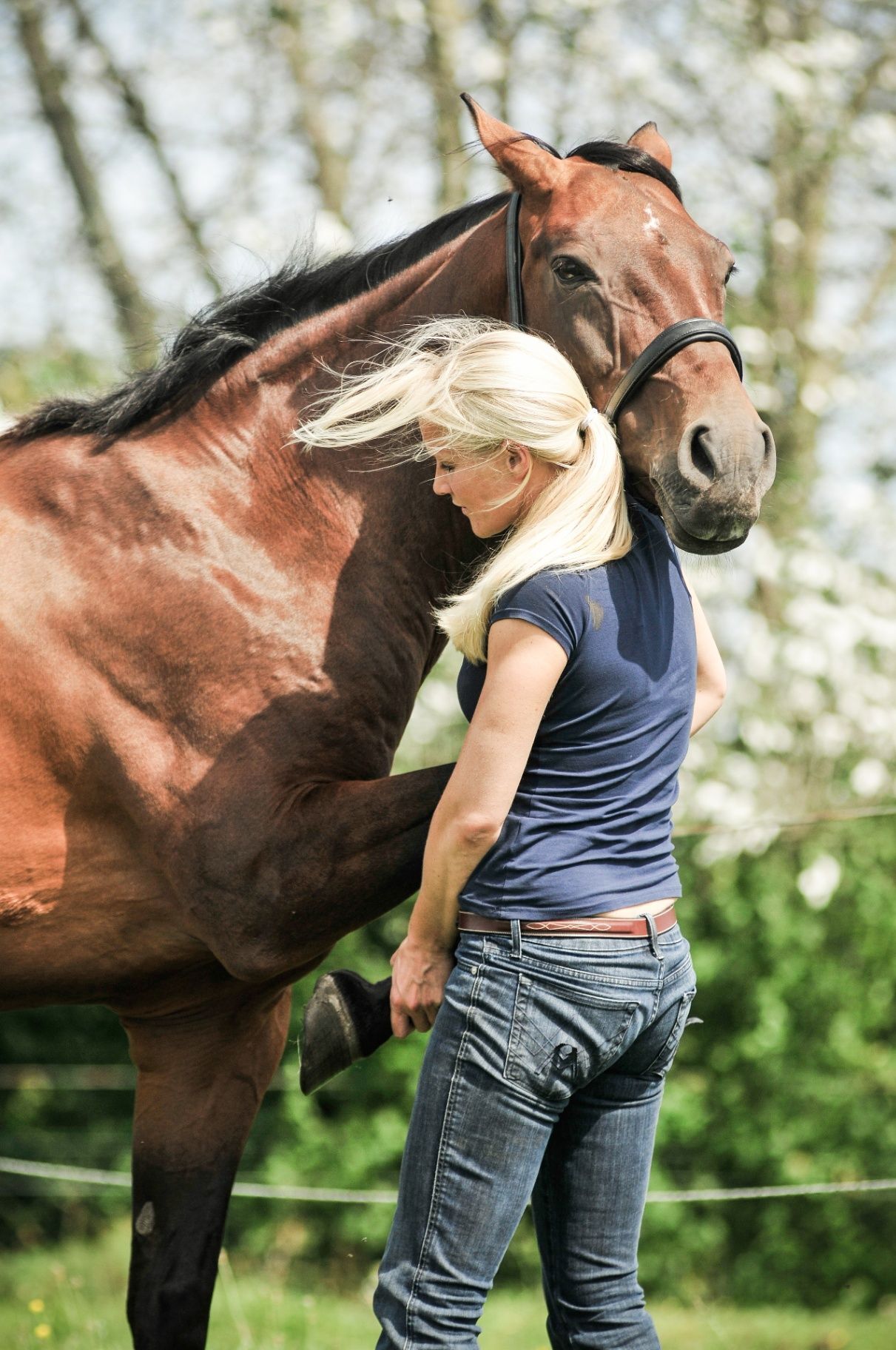 Evy met een paard dat zijn hoofd op haar schouder laat rusten